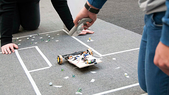 Remote controlled vehicle on obstacle course of marbles